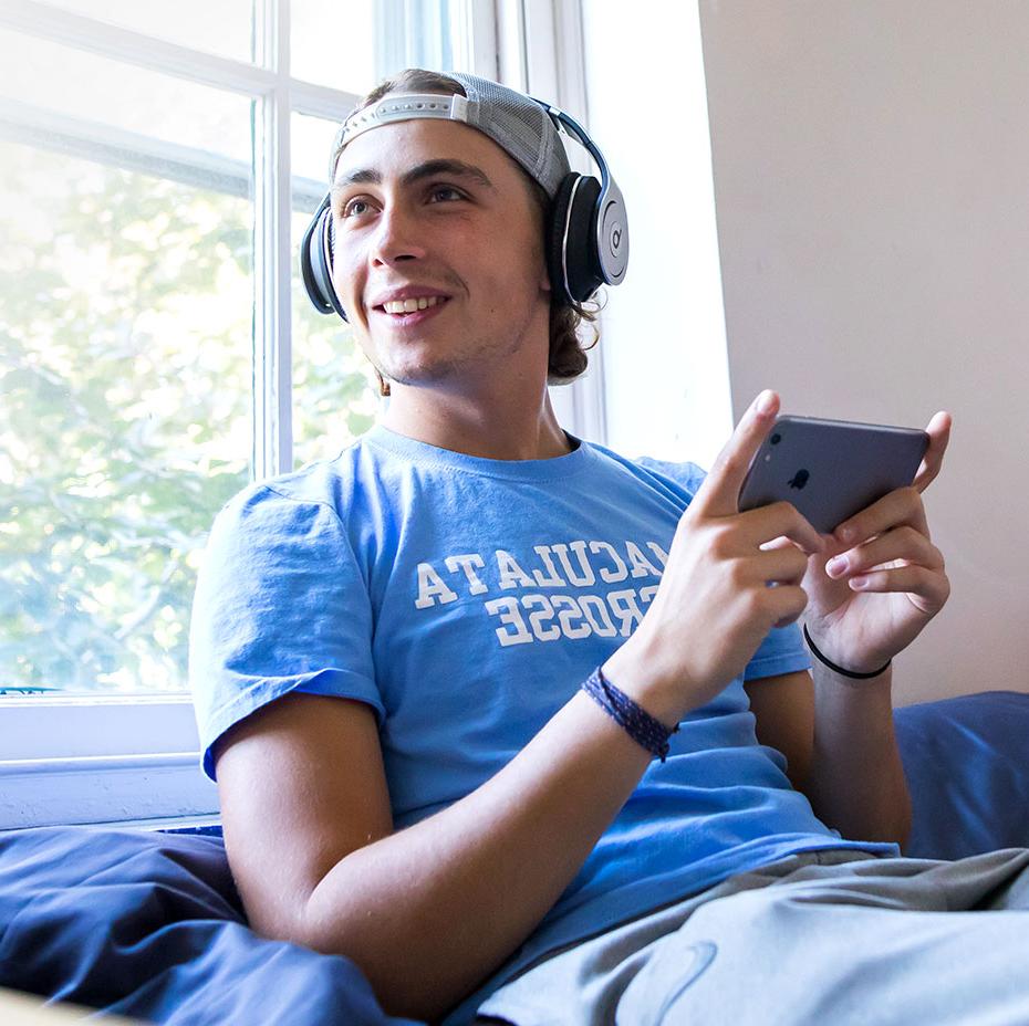 Student in dorm room with headphones on